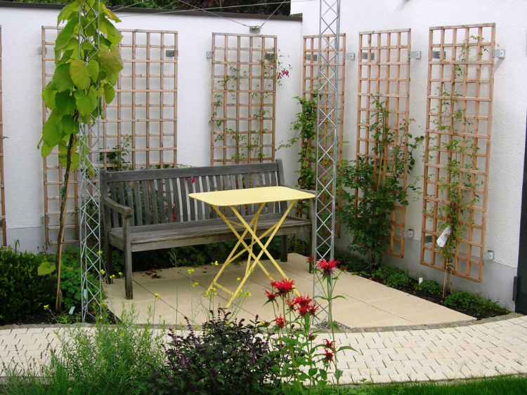 Kleiner romantischer Sitzplatz mit Holzspalieren für Rosen und Clematis. Gartengestaltung in Freiburg, Helmut Lamprecht