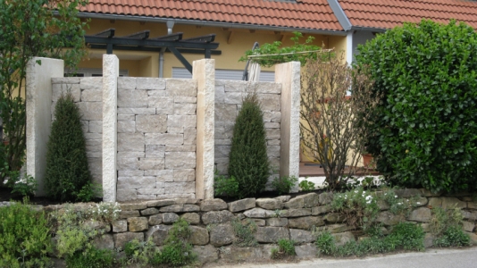 Gartengestaltung mit Sichtschutz aus Natursteinmauern und Stelen. Kleiner Garten in Vörstetten. Gartenplaner Helmut Lamprecht